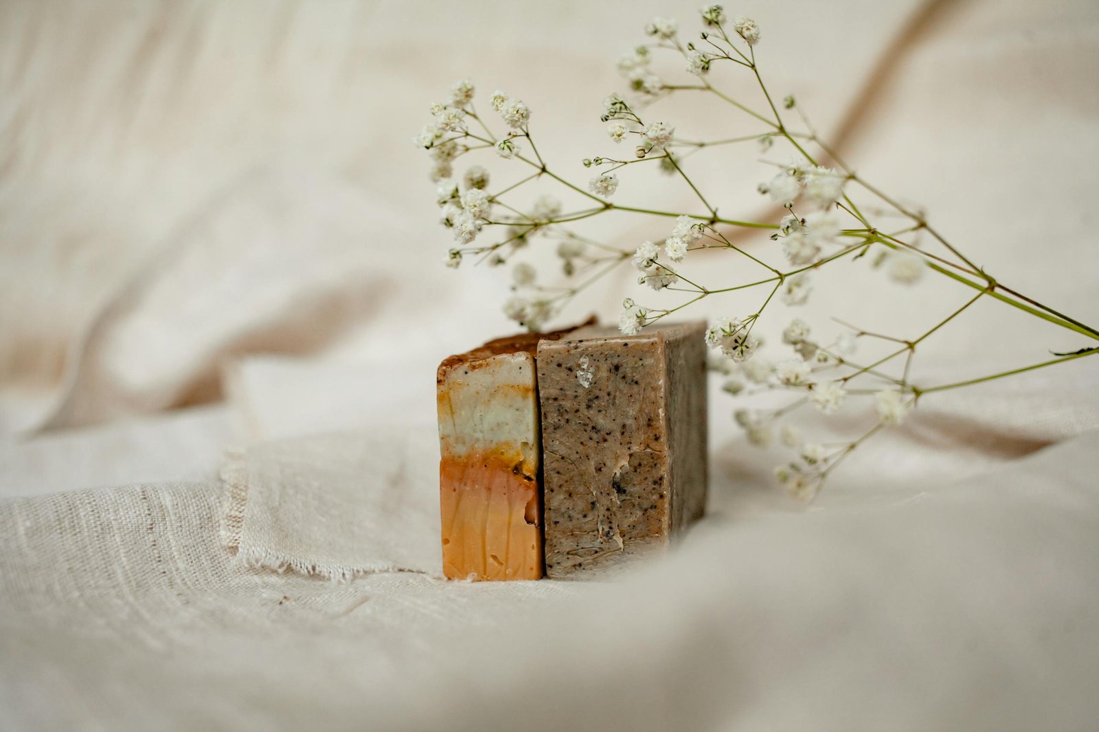 Minimalist arrangement of artisanal soaps with delicate flowers for a natural touch.